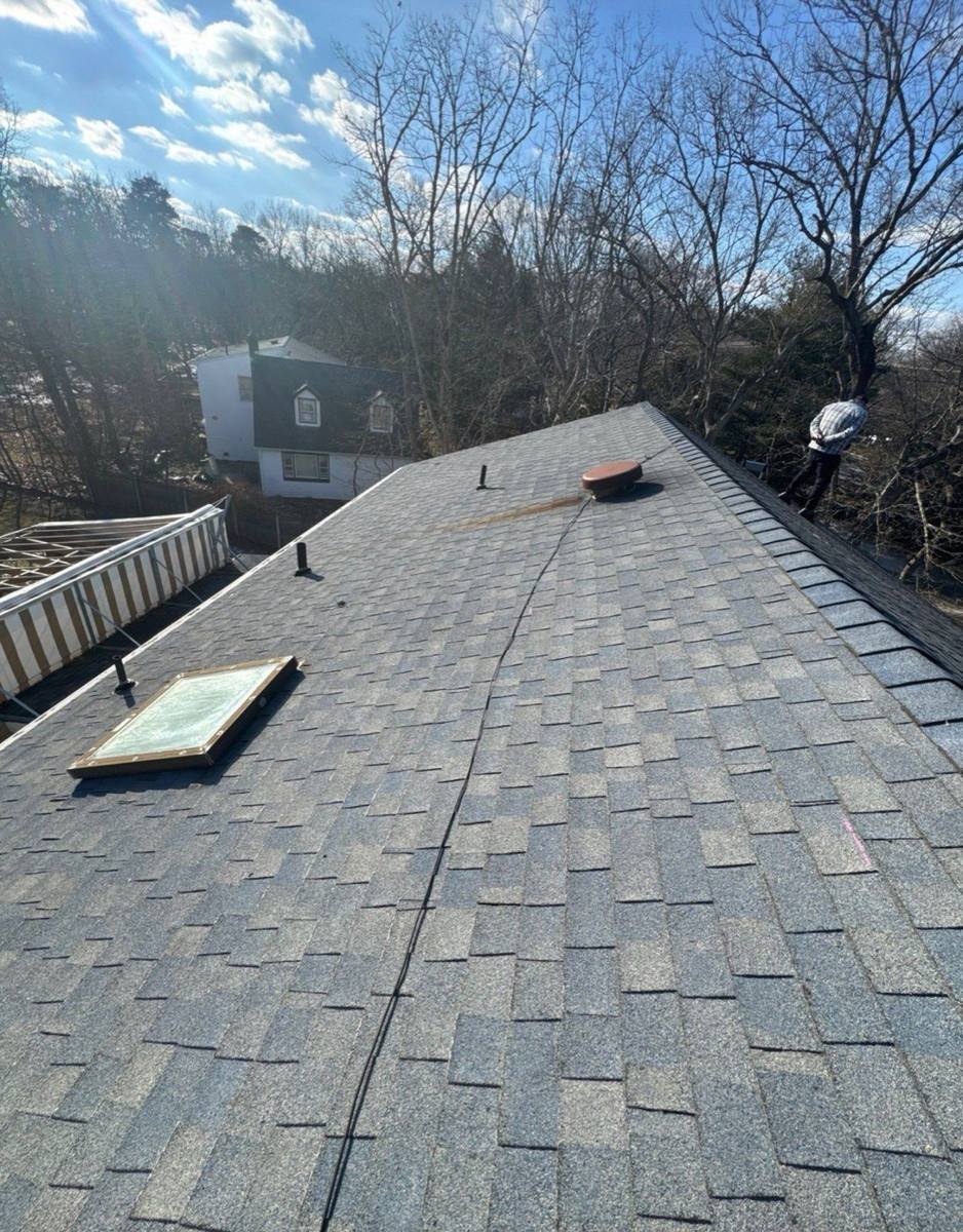 Worn warm-brown shingles on a residential roof before replacement